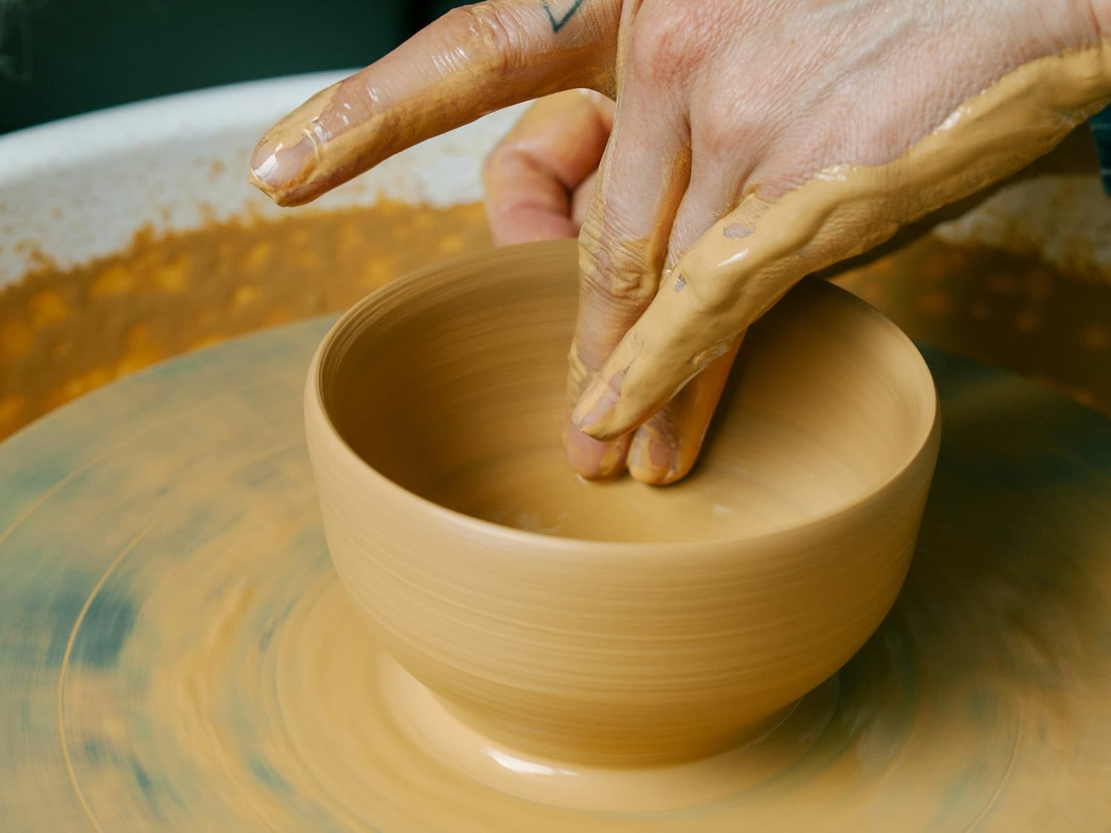 A bowl being shaped on a pottery wheel
