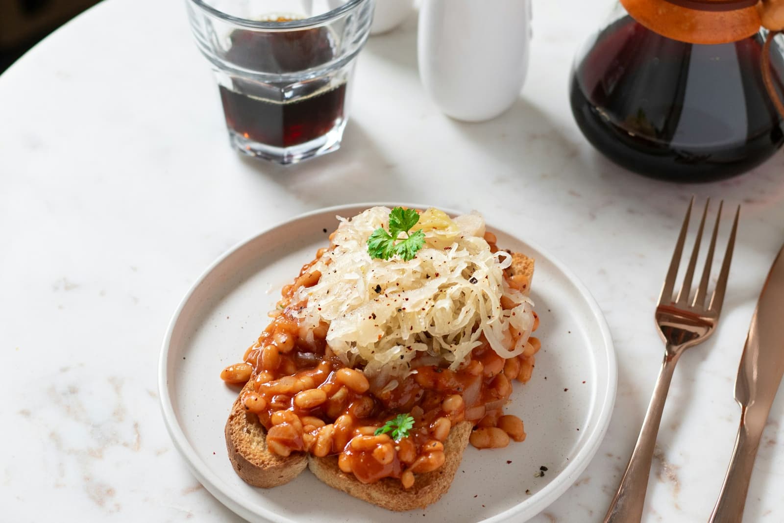A piece of toast covered in beans on a white plate
