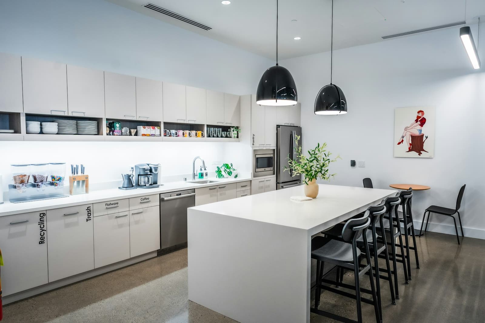 A tidy kitchen with a large island and black stools