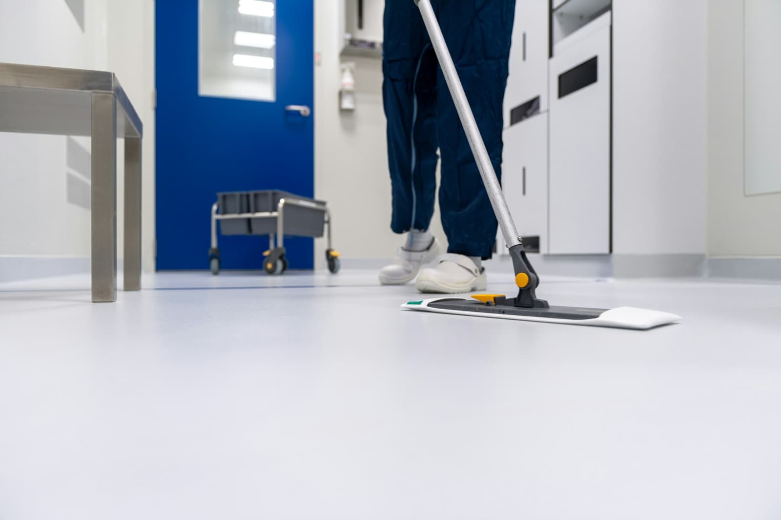 A cleaner mopping a white floor