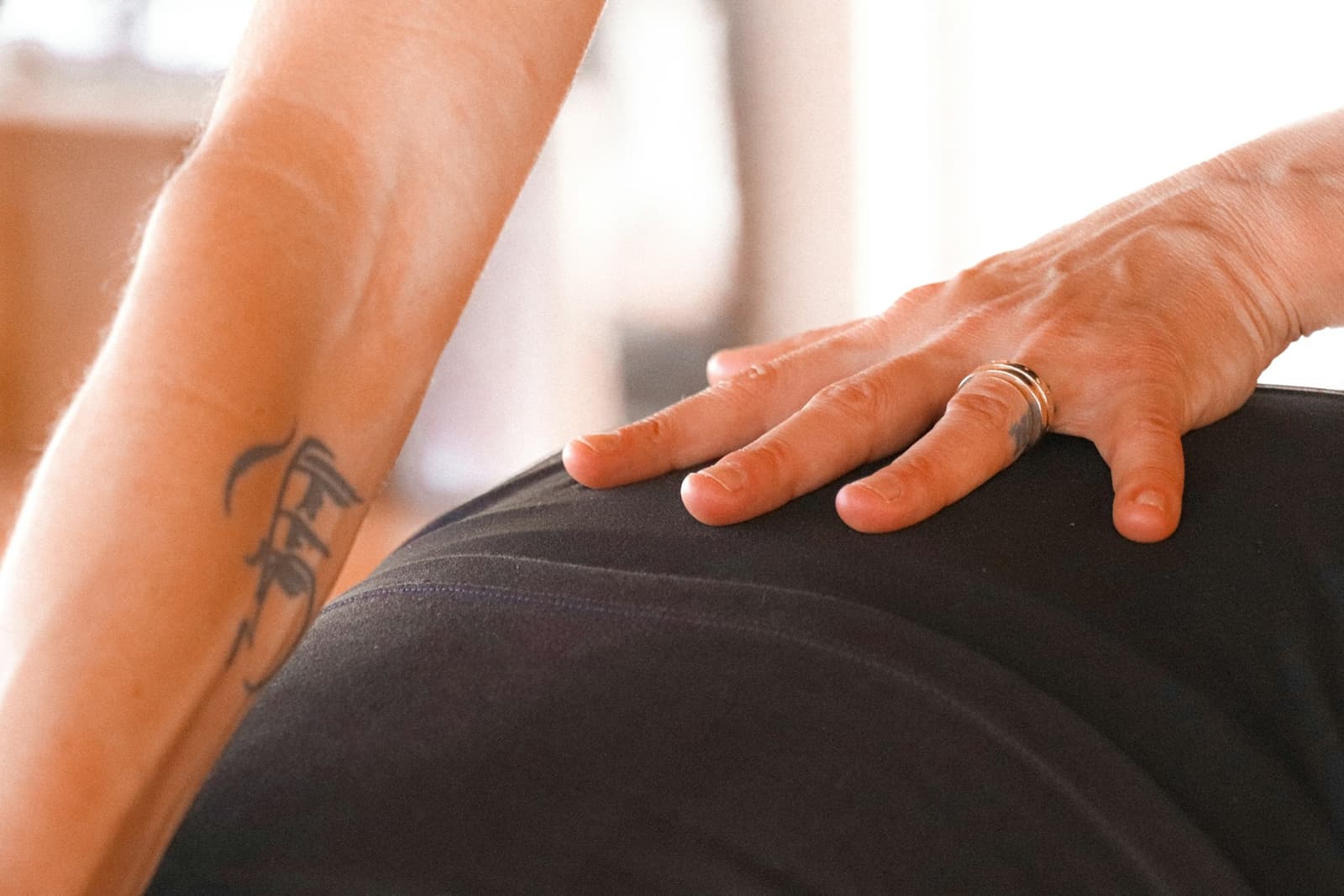 A hand resting on a person's lower back during a massage