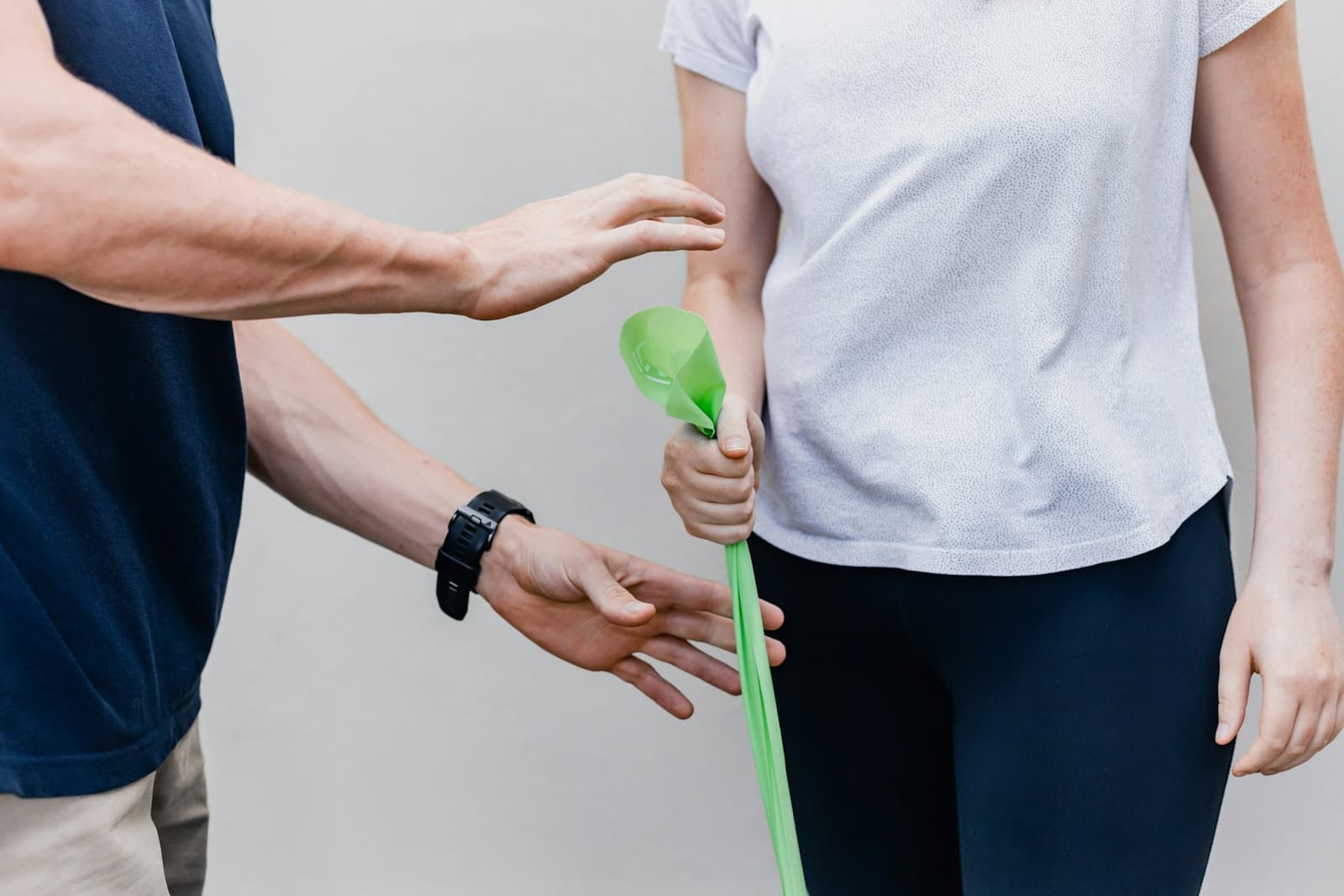 A person holding a green resistance band