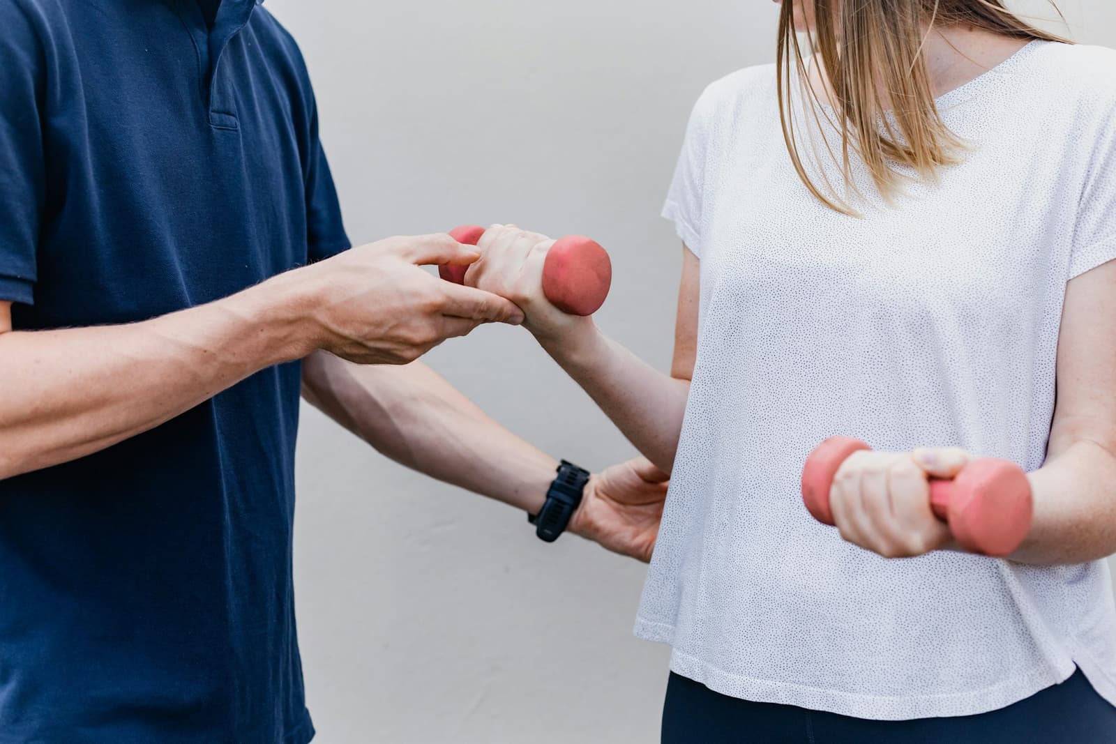 Two people working through an exercise with hand weights