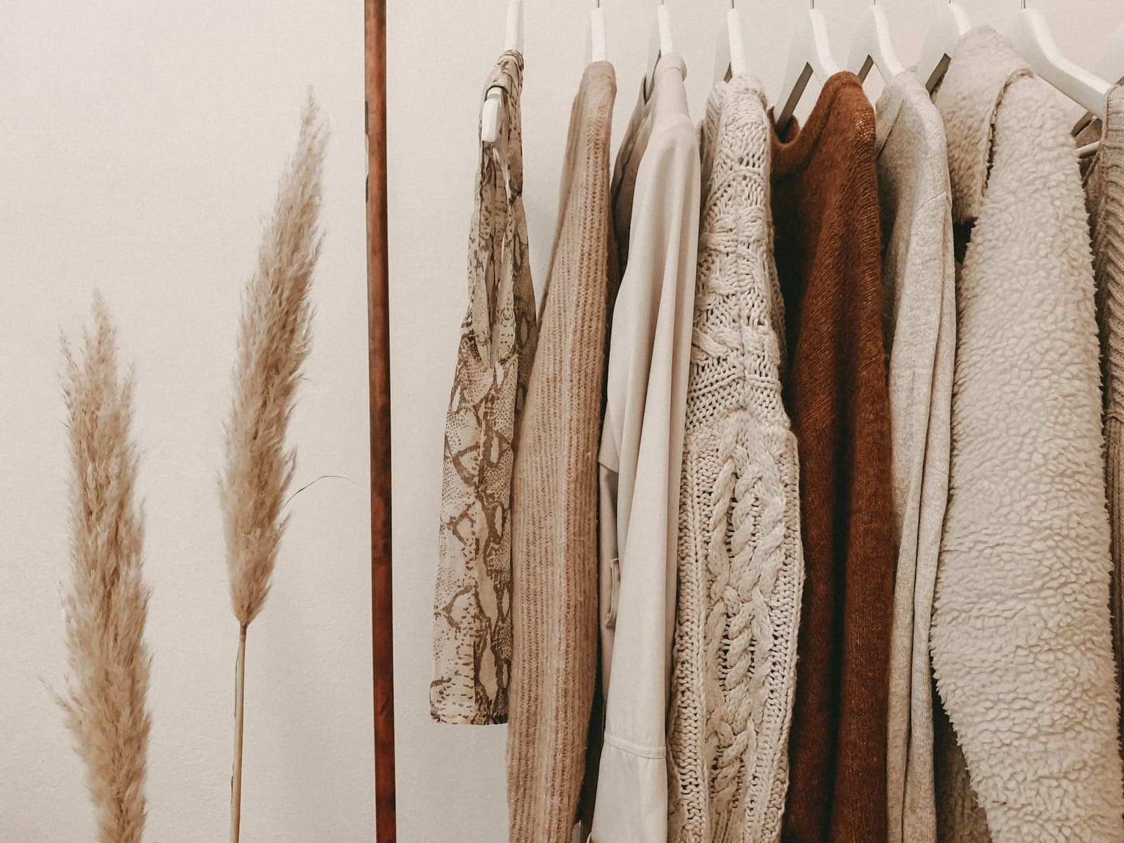 A knitted top hanging on a wooden clothes horse