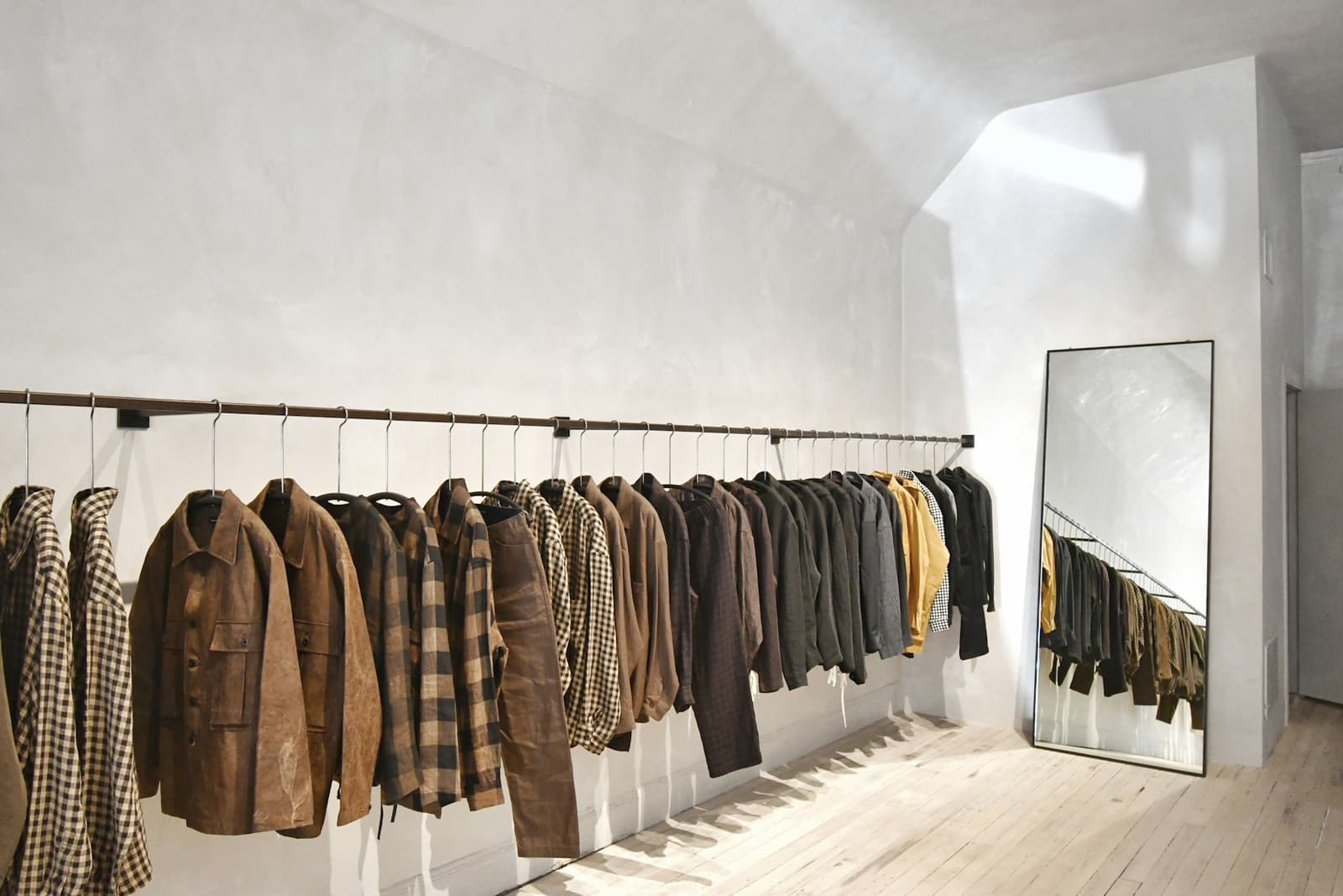A rail of clothes hanging on a wall